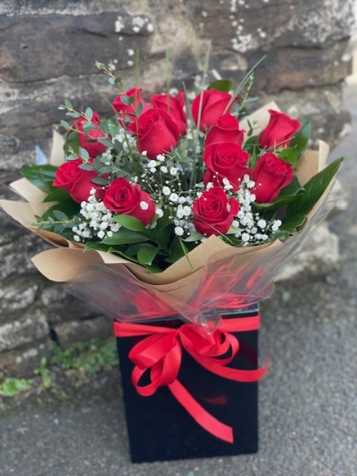 Romantic 12 red roses with gypsophila and seasonal foliage